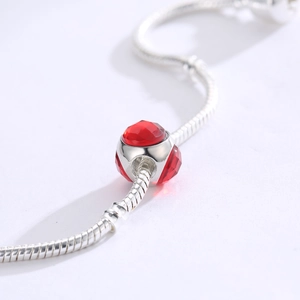 Macro di un ciondolo in cristallo rosso sfaccettato su un bracciale a serpente