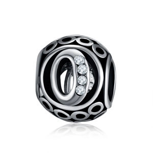 Detailed view of silver letter O charm with sparkling crystals and black enamel rings