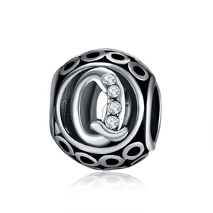 Macro view of a silver hollow charm bead featuring an engraved letter Q with cubic zirconia