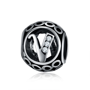 Macro shot of silver alloy charm bead with letter V and white zircon stones