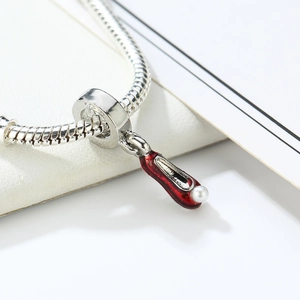 Silver snake chain necklace featuring red enamel high heel pendant with pearl detail