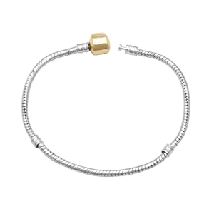 Detail van zilveren slangenketting armband met gouden tonvormige sluiting en stoppers