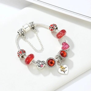 Close-up of silver snake chain bracelet with red crystal beads and I love you heart charm