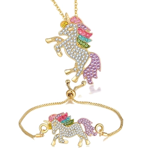 Detail view of unicorn necklace and bracelet set with colorful crystals and gold plating