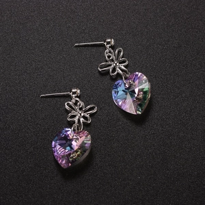 Detail of vintage heart crystal earrings featuring silver floral accents and aurora finish