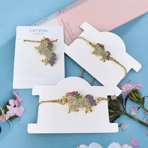Detailed shot of gold unicorn jewelry set with colorful rhinestones on display card