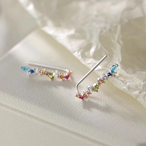 Macro shot of colorful zircon curved ear hooks with vibrant multicolor gemstones on silver metal