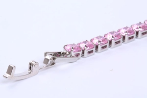 Close-up of pink zircon tennis bracelet with silver prong setting and secure fold-over clasp