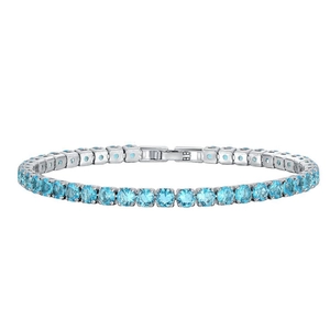 Macro shot of silver tennis bracelet featuring round-cut light blue stones and B.B clasp