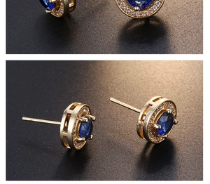 Makro-Detail runder blauer Saphir-Ohrstecker mit weißem Zirkonia-Halo und Goldbeschichtung