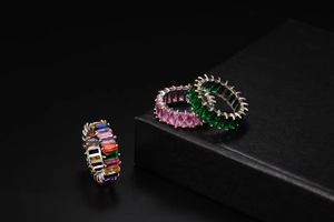 Détail macro de trois bagues en zircone rectangulaire aux couleurs arc-en-ciel, rose et vert