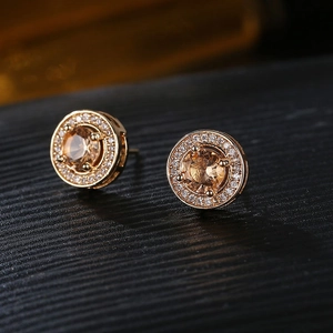 Makroaufnahme vergoldeter Ohrstecker mit champagnerfarbenem Zirkon und Diamantkranz