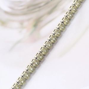 Detail view of champagne zircon tennis chain with silver metal claw setting