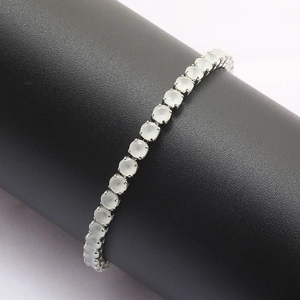 Detail of a silver tennis bracelet featuring translucent light green round cut gemstones