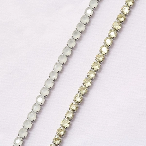 Macro detail of silver claw setting with milky white and champagne zircon stones