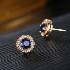 Detailansicht der runden Halo-Ohrringe mit blauem Zirkon und rosévergoldeter Pavé-Fassung
