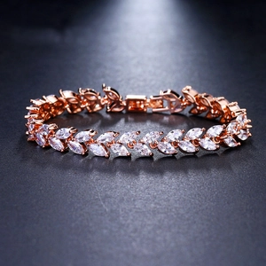 Macro detail of rose gold marquise-cut zircon leaf bracelet with fold-over clasp closure