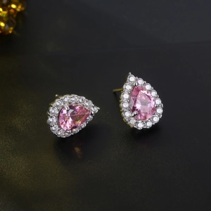 Macro side view of teardrop pink zircon earrings with white pave halo in silver