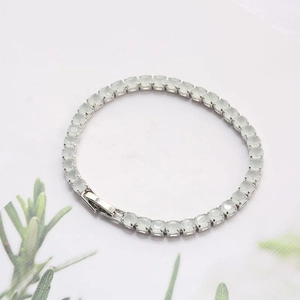 Elegant tennis bracelet with pale green stones and silver-tone four-prong setting