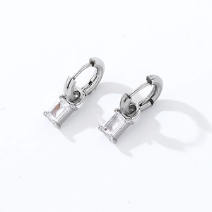 Macro detail of silver square zircon earrings with sleek emerald-cut transparent stones