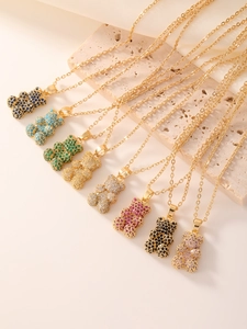 Close-up of sparkling teddy bear pendants with zircon inlay and golden chain details