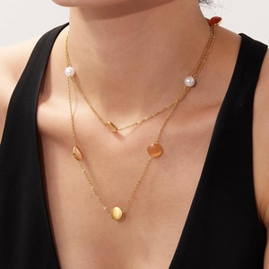 Zweilagige goldene Halskette mit Katzenaugenperlen und geometrischen Anhängern am Model