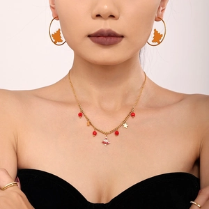 Christmas jewelry set with gold star necklace and enamel tree hoop earrings on model