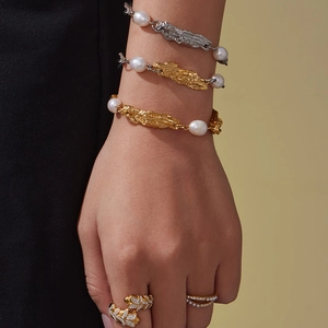 Set aus unregelmäßigen Metallketten und Süßwasserperlen-Armbändern an einem Modell