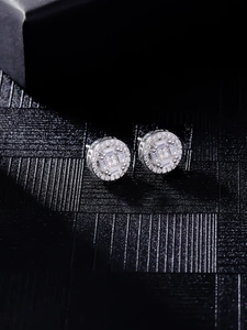 Macro detail of round cluster stud earrings with baguette-cut stones and side engraving