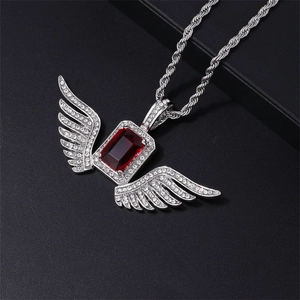 Detail view of iced-out wing pendant with red gemstone and silver rope chain