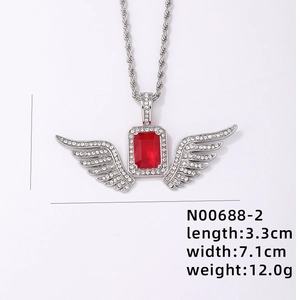 Detail view of angel wing pendant with red gemstone and white crystals on rope chain