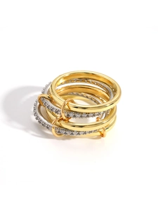 Detail of multi-layer gold and silver rings with zircon inlay and interlocking design