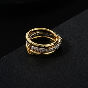 Macro shot of interlocking triple ring bands in gold and silver with pave zircon stones