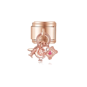 Maillon de bracelet en or rose avec pendentifs avion, globe et valise sur fond blanc pur