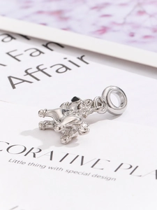 Macro shot of silver zodiac horse charm featuring black gemstone eyes and ornate metalwork