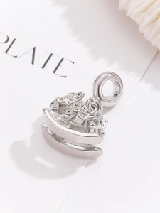 Detailed macro view of a silver rocking horse pendant with intricate engraved saddle patterns