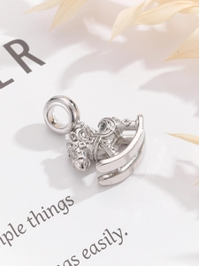 Macro shot of a silver rocking horse charm with intricate star patterns and a metallic finish
