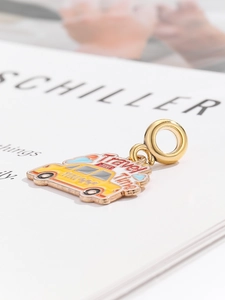Detail of yellow enamel taxi charm with Travel Time text and golden metal base