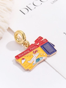 Macro shot of gold-plated boarding pass pendant with colorful enamel and plane detail