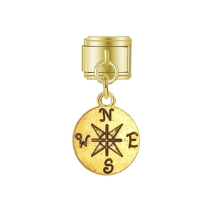 Détail d'un charm modulaire doré avec un pendentif boussole mat et une étoile gravée