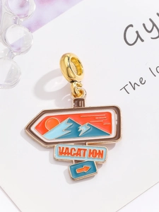 Macro view of gold vacation road sign charm with blue enamel mountain and red sun detail