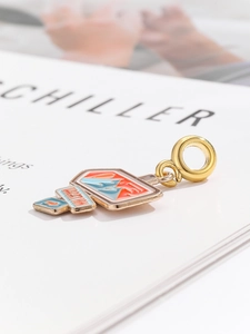 Detailed view of airplane suitcase charm with colorful enamel inlay for travel bracelets