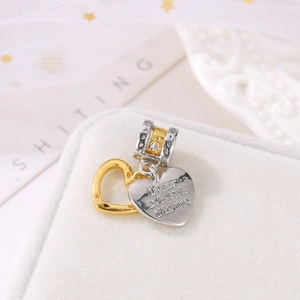Dual heart charm in gold and silver with Dreams are the seeds of the future engraving