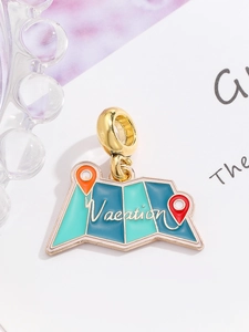 Macro detail of a gold vacation map charm with blue enamel and small pin details