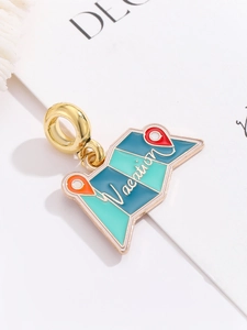 Close-up of golden enamel vacation charm with colorful world map for DIY jewelry making