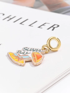 Macro detail of Sunny Day enamel beach charm with umbrella and chair on gold metal