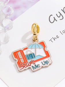 Macro shot of an orange and blue enamel travel suitcase charm for DIY jewelry bracelets