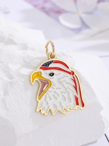 Close-up of golden eagle pendant with American flag pattern on a white stone background