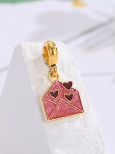 Nahaufnahme des goldenen Umschlag-Charms mit rosa Emaille und roten Herzen für Schmuck