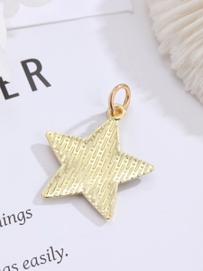 Macro view of a gold star-shaped pendant with fine textured stripes and a metal ring
